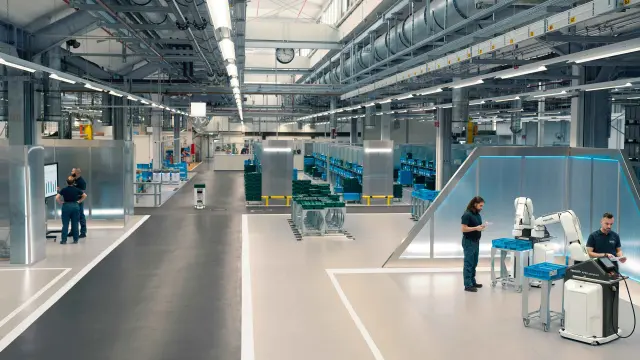 People, AGVs and robots work together in a modern industrial plant.