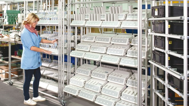Empleado delante de una estantería de trabajo EcoShape de Bosch Rexroth